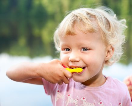 Portrait of cute little girl  brushing teeth  outdoor