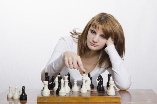 Young girl playing chess. Girl ponders the next move