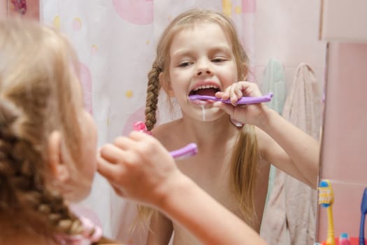 Five-year girl brushing her teeth in the bathroom