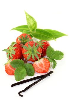 a vanilla bean with vanilla leaves and fresh strawberries