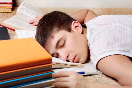 Tired Teenager sleeping with the Books on the Sofa