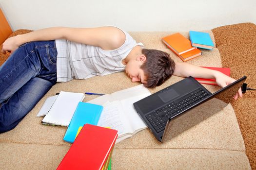 Tired Teenager sleeping on the Sofa with the Books