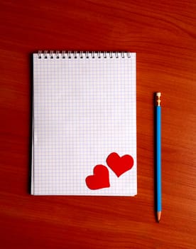 Blank Writing Pad with Heart Shapes and Pencil On The Table