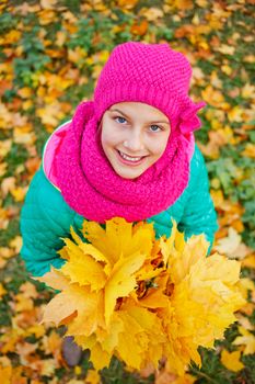 Portrait of Adorable cute girl with autumn leaves in the beauty park