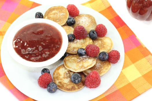 Dutch Poffertjes with berries before light background