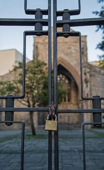 A locked gate, with a church in the background