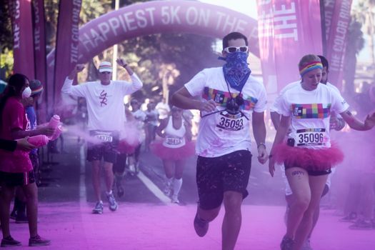 Ventura, CA - OCTOBER 18 : Participants coming through the pink color station at The Color Run 2014 in Ventura. OCTOBER 18, 2014 in Ventura, CA.