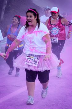 Ventura, CA - OCTOBER 18 : Participants coming through the pink color station at The Color Run 2014 in Ventura. OCTOBER 18, 2014 in Ventura, CA.