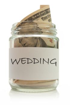 Dollar banknotes inside a glass jar over a white background