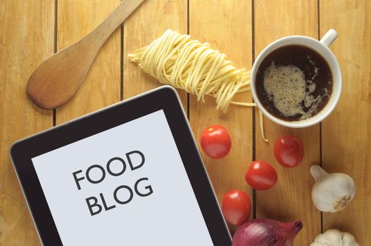Food blog heading on a tablet surrounded by fresh food ingredients