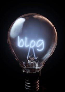 Blog illuminated bulb over a black background