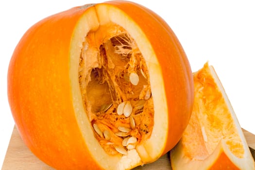 Ripe pumpkin on a cutting Board, cut along, see the middle of the pumpkin and sunflower seeds. Presented on a white background.