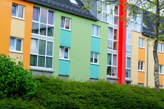 Colourful facade game, old brickwork with new colored houses front.
