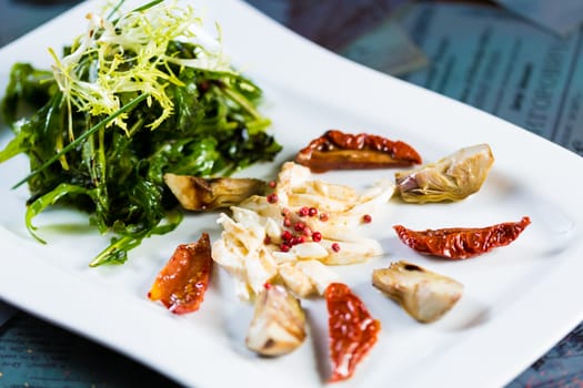 Fresh salad with sun-dried tomatoes and cheese in the Italian style. Healthy Food