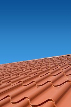new roof with orange sheet metal and background of blue sky