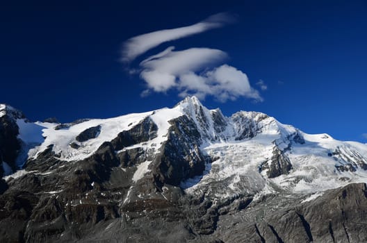 high snowy mountain peaks and glaciers rocks withdeep blue sky