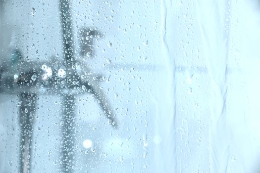 Water dropping down the glass of a shower.