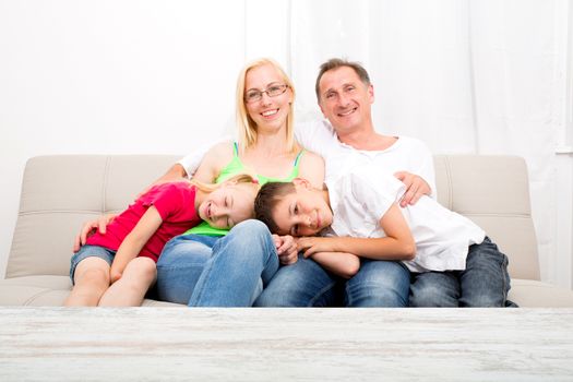 Happy family sitting together on the couch
