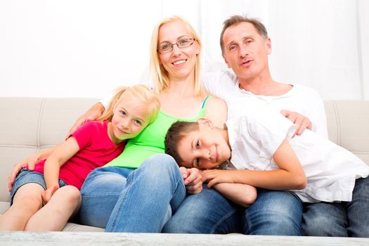 A happy Family at home on the sofa.