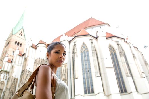 Hispanic girl in front of the Cathedral of Augsburg.
