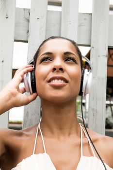 A young hispanic girl enjoying music outdoor.