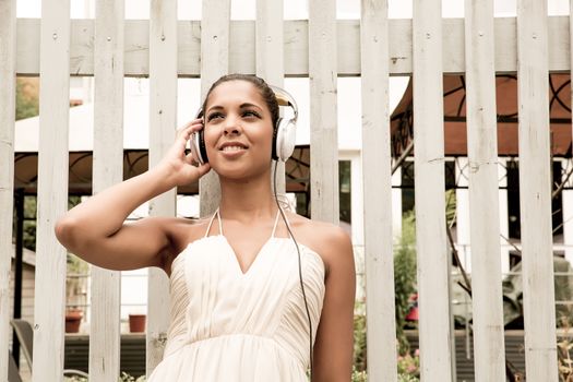 A young hispanic girl enjoying music outdoor.