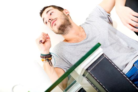 Portrait of a young man in grey shirt in the office.
