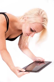 Portrait of a blonde alternative girl lying on the ground holding a tablet PC.