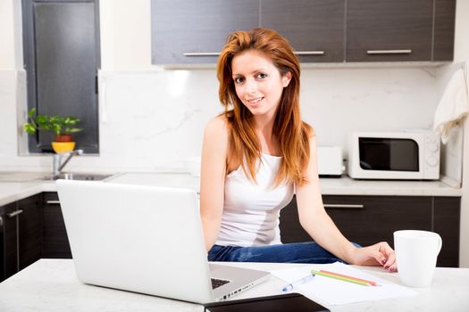 Portrait of a brunette girl working in the kitchen.