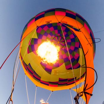 Fire heats the air inside a hot air balloon at balloon festival 