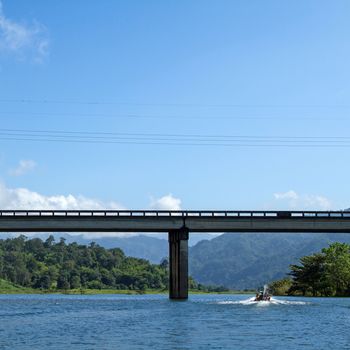 bridge across river with mountain blue sky