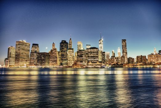 New York City. Delightful Manhattan downtown skyline at dusk with skyscrapers illuminated over East River panorama.