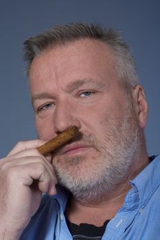 studio portrait of a middle aged man in shirt with a cigar