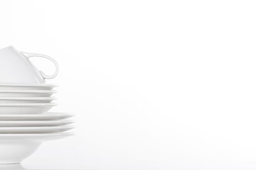 studio shot of a pile of white plate and white cup isolated on white - copy space