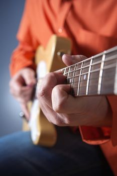 closeup of hands of a musician playing electric guitar