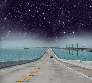 Infinite road to the ocean with stars in the night.