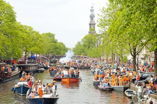 AMSTERDAM - APRIL 26: Amsterdam canals full of boats and people in orange at the Prinsengracht during the celebration of kings day on April 26, 2014 in Amsterdam, The Netherlands