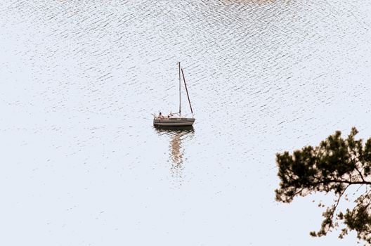 Sailing ship yachts with white sails on a lake.