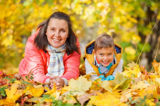 Portrait of mother with her son relaxing in autumn park