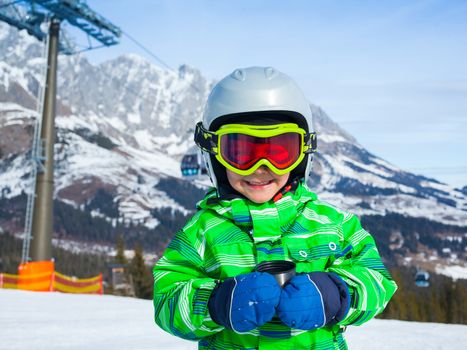 Ski, skier, winter. Lovely small boy has a fun on ski -  resting and drinking tea from a thermos.