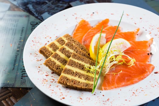 Salmon snack on the white plate, studio shot