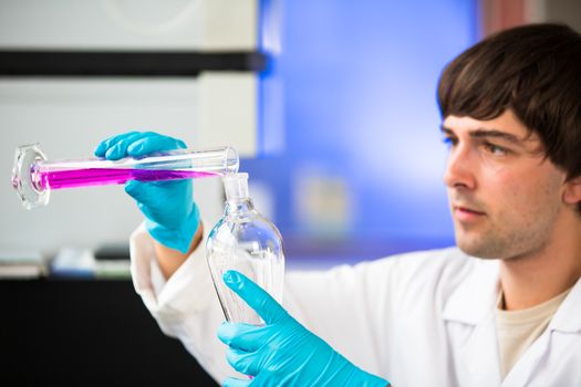 Young male researcher carrying out scientific research in a lab (shallow DOF; color toned image)