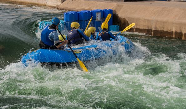 A rubber raft, taking on water, as it goes backwards through the rapids