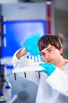 Young male researcher carrying out scientific research in a lab (shallow DOF; color toned image)