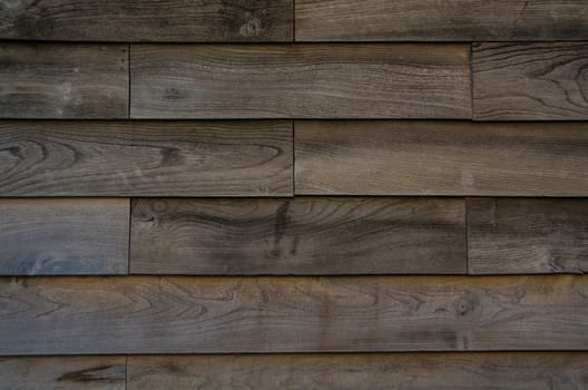 A close up of a wooden wall, showing the horizontal wood planks making up the wall