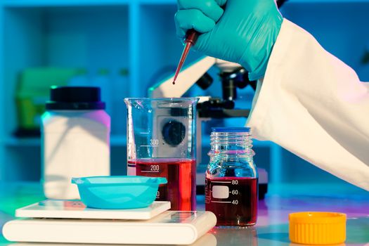 researchers work in modern scientific lab. Preparation of hazardous solution
