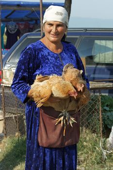 KABALI, GEORGIA - JULY 6, 2014: Woman selling poultry on the cattle market of Kabali on July 6, 2014 in Georgia, Europe