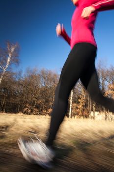 Young woman running outdoors on a lovely sunny winter/fall day