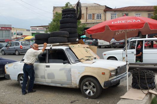 TELAWI, GEORGIA - JULY 5, 2014: Man selling tires on a typical Georgian market on July 5, 2014 in Telawi, Georgia, Europe