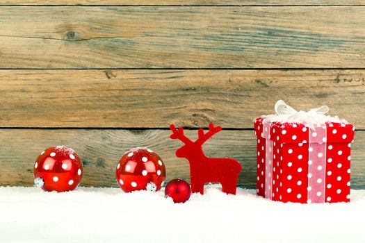red gift for christmas on a wooden background with snow